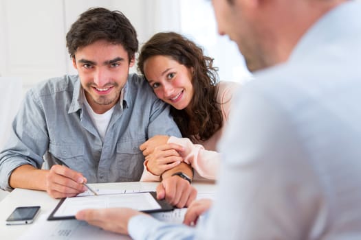 View of a Young attractive couple signing contract