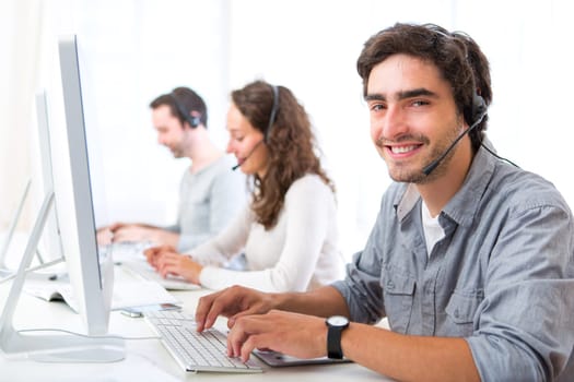 View of a Young attractive man working in a call center