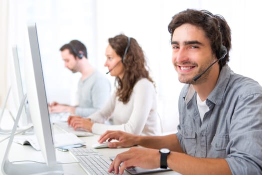View of a Young attractive man working in a call center