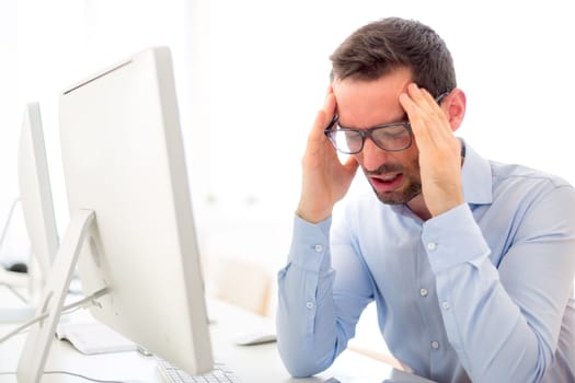 View of a Young attractive man got a headache at the office