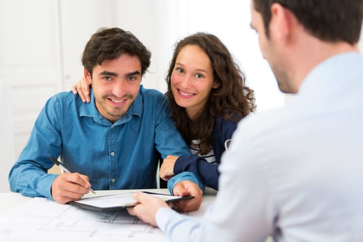 View of a Young attractive couple signing contract