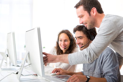 View of a Group of people working around a computer