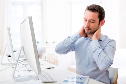 View of a Young attractive man got a neck pain at the office