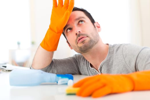 View of a Young attractive man cleaning his flat