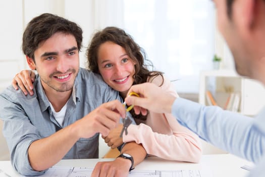 View of a Real estate handing over keys to couple