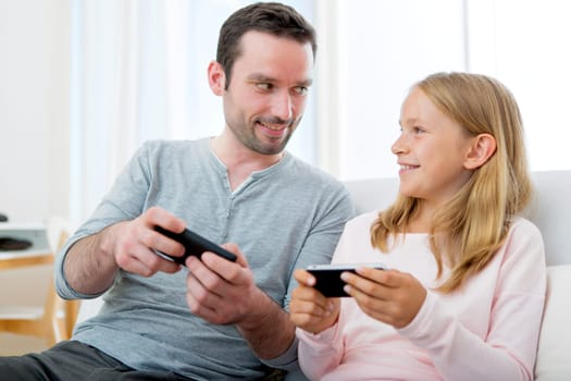 VIew of a Father and his blond daughter using mobile