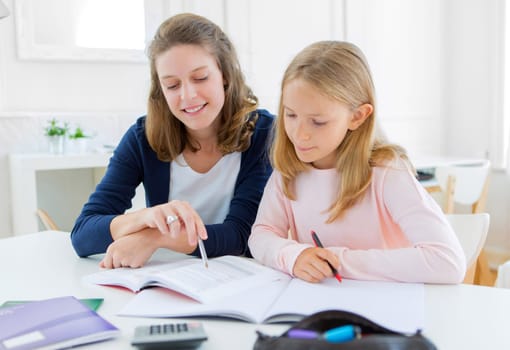 View of a Woman helping out her little sister for homework