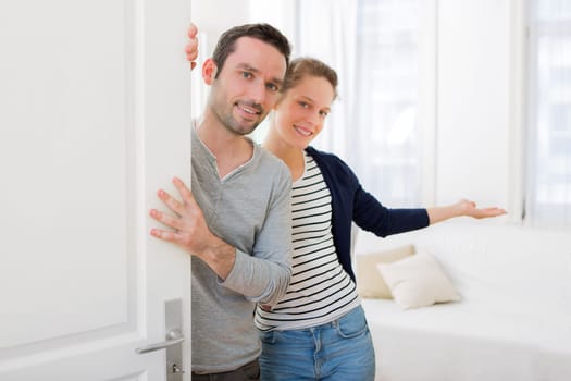 View of a Young attractive couple welcoming you in his house