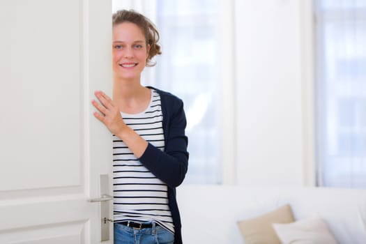 View of a Young attractive woman welcoming you in his house