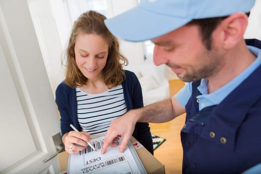 View of a Young attractive woman signing on delivery paper
