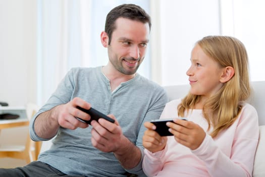 VIew of a Father and his blond daughter using mobile
