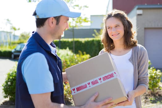 View of a Delivery man handing over a parcel to customer