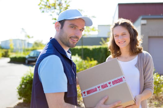 View of a Delivery man handing over a parcel to customer