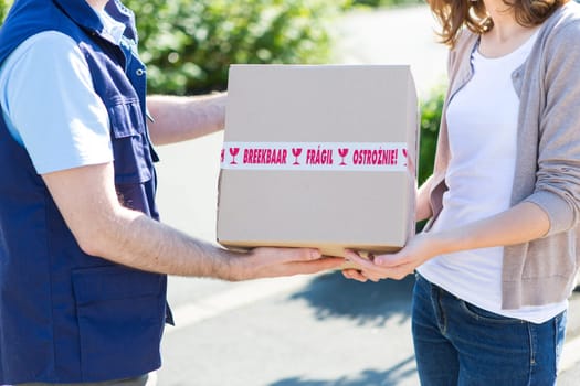 Detailed view of a parcel being handed over by a professional