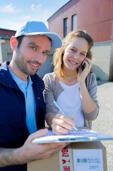 View of a Young attractive woman phoning during a delivery