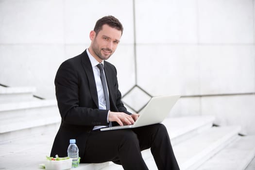 Attractive businessman keep working during lunch break