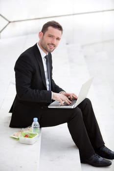 Attractive businessman keep working during lunch break