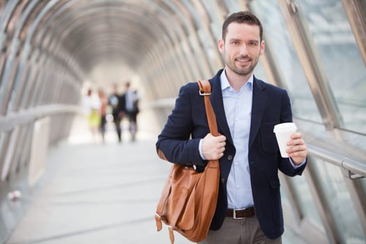 View of a Young attractive man drinking coffee on his way
