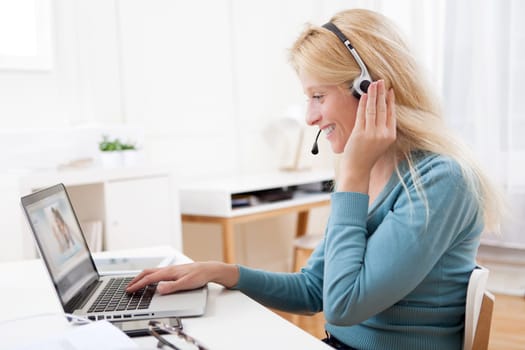 View of Young attractive woman blonde chatting on laptop