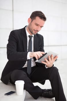 View of an attractive businessman using a tablet