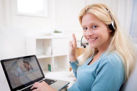 View of Young attractive woman blonde chatting on laptop