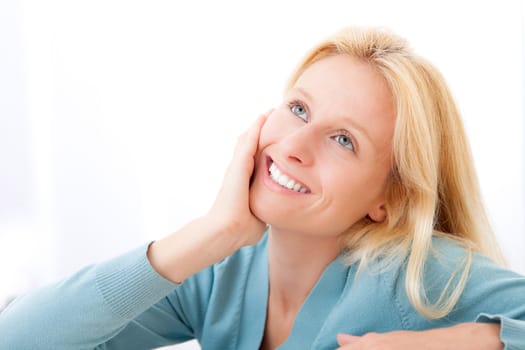 View of an Attractive pensive blonde woman in a sofa