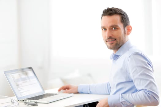 View of a Young business man working at home on his laptop