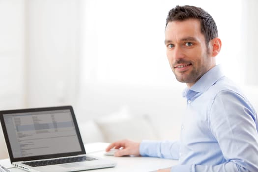 View of a Young business man working at home on his laptop