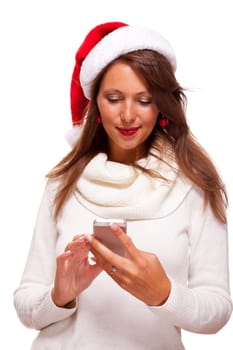 Attractive woman with red Santa hat reads a text message on her phone smartphone and sends Christmas wishes smiling with joy isolated on white with text-free free-space