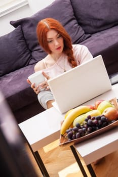 Young woman with laptop leisure time at home in living room