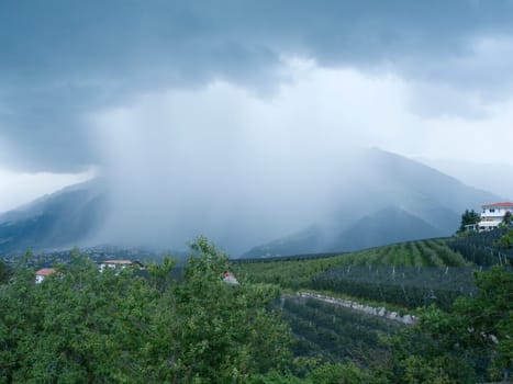 wide-angleview of the Merano valley with a rain cloud above it in summer
