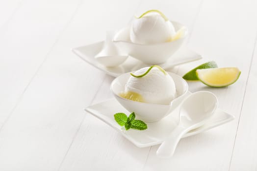 Fresh lemon and lime ice cream in a white cup.