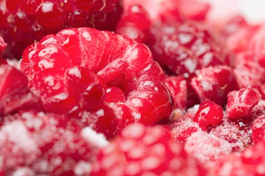 format-filling macro view of thawing raspberries with isolated frost crystals