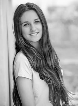 Outdoor portrait of beautiful teenage girl in spring in black and white.