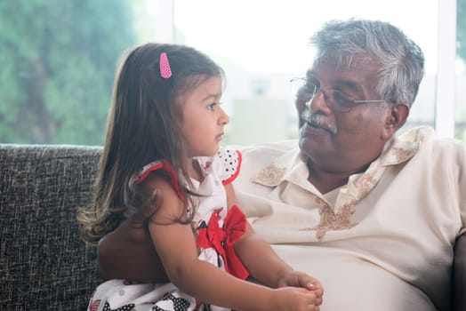 Portrait Indian family at home. Grandparent and grandchild talking together. Asian people living lifestyle. Grandfather and granddaughter.