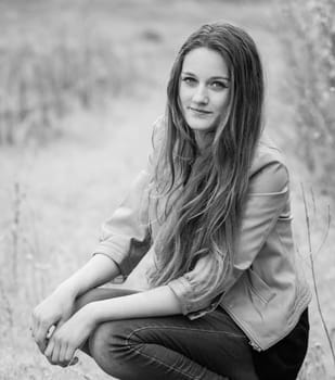 Outdoor portrait of beautiful teenage girl in spring in black and white.