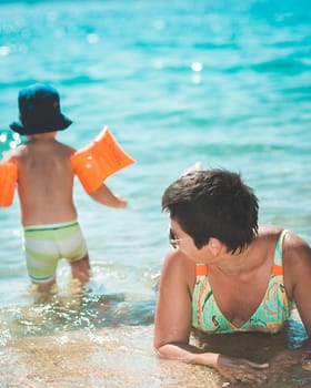 Mother looking after baby going swimming