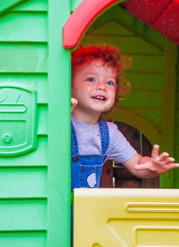 Baby boy in a toy house at home.