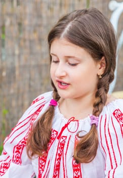 Portrait of a 10 year old girl wearing a Romanian traditional blouse.