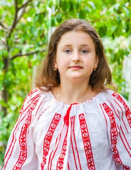 Portrait of a 10 year old girl wearing a Romanian traditional blouse.