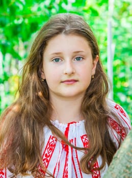 Portrait of a 10 year old girl wearing a Romanian traditional blouse.