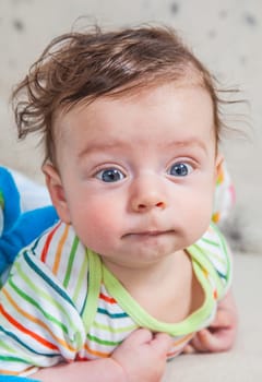 Portrait of an adorable smiling baby playing with a monkey toy.