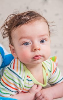 Portrait of an adorable smiling baby playing with a monkey toy.
