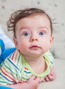 Portrait of an adorable smiling baby playing with a monkey toy.