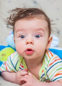 Portrait of an adorable smiling baby playing with a monkey toy.