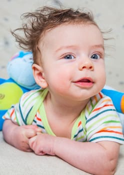 Portrait of an adorable smiling baby playing with a monkey toy.