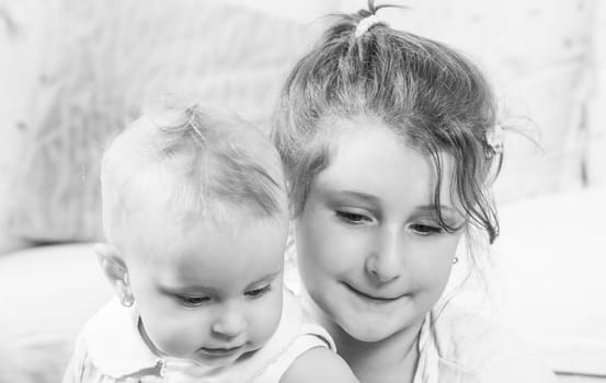 Big sister holding her 1 year old baby sister.