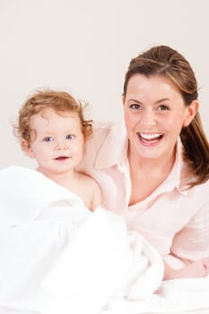 Mother posing with daughter after her bath whilst she is wrapped in a towel