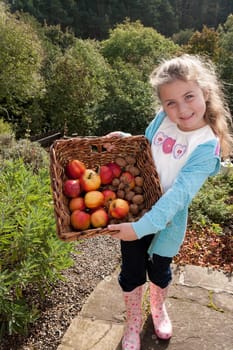 Young girl posing with a basket of hand-picked fruit