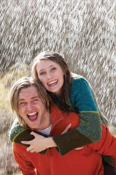 Young couple playing in the rain without an umbrella